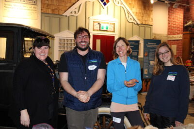 Three staff and one volunteer stand together smiling
