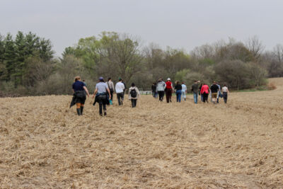 Several staff walking through a farm field