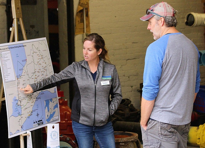 Staff and landowner look at map showing municipal water sources