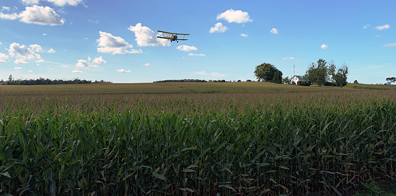Plane flying over crop dropping seed