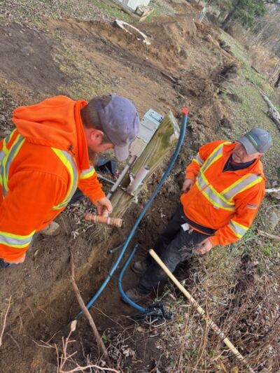 Two men in a trench installing water lines