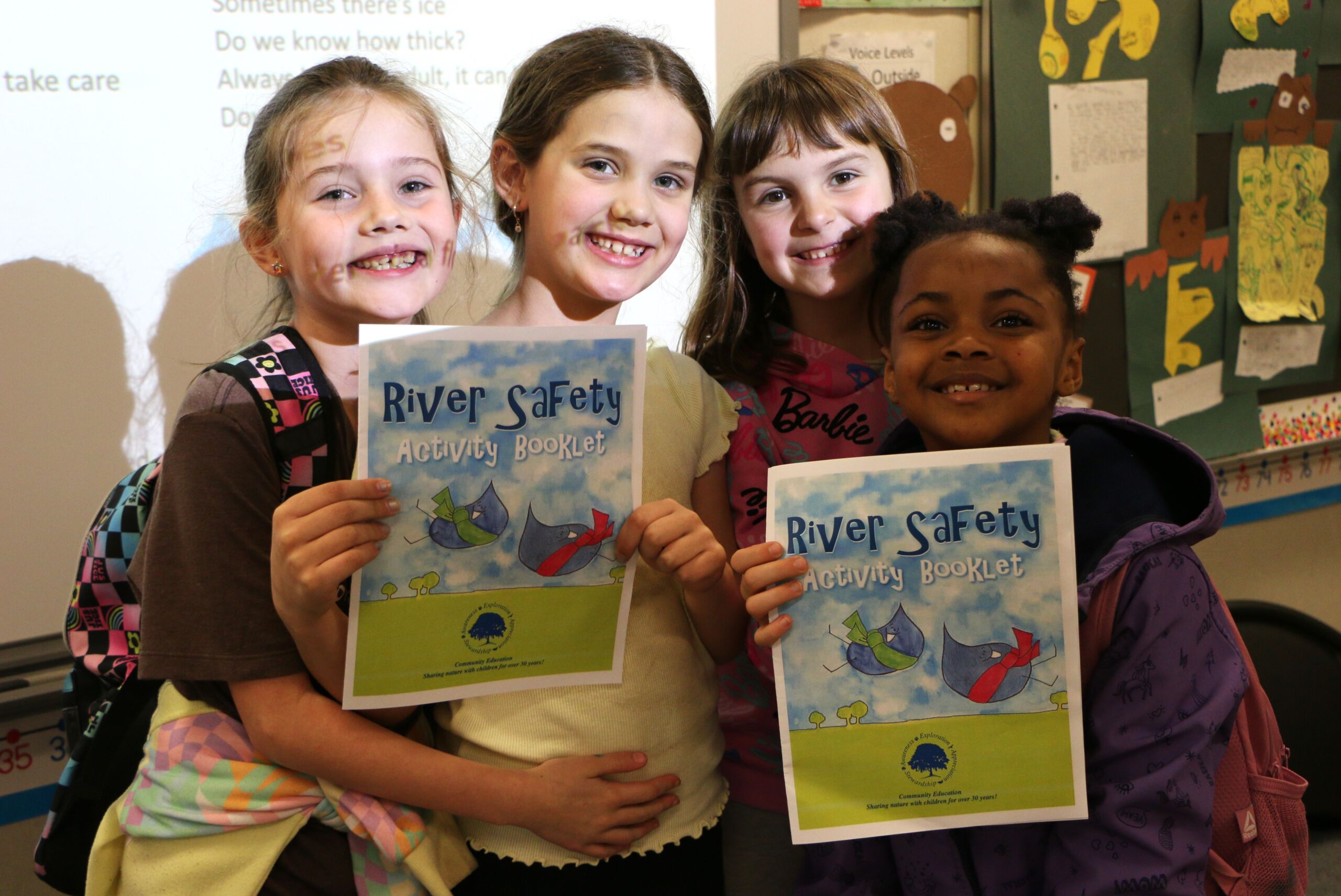 Photo of four children holding River Safety booklets