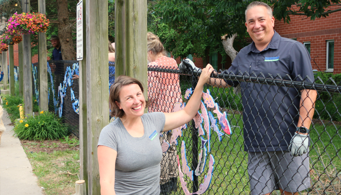 UTRCA staff install painted fish on fence