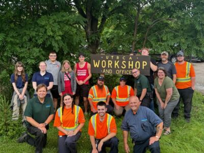 Pittock staff posing with sign