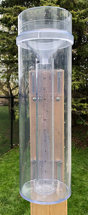 Plastic tube for measuring rain, mounted on a wooden post