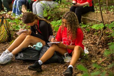 Two students sitting on the ground making notes at Fanshawe CA